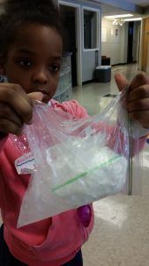 A student making ice cream in a bag to learn about freezing points.